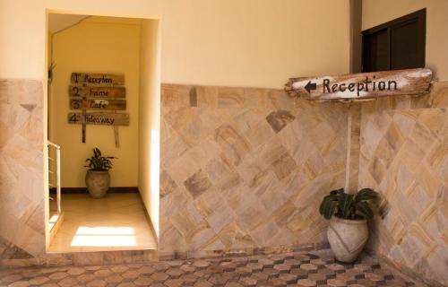 uma placa numa parede num quarto com piso em azulejo em Lilac Elevate Inn em Karatu