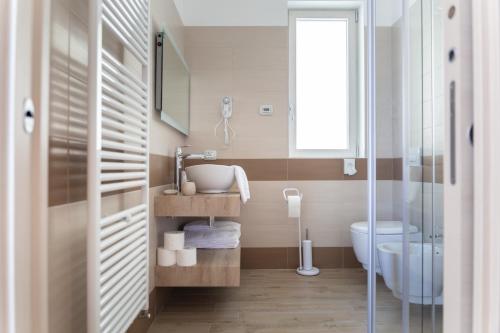 La salle de bains est pourvue d'un lavabo et de toilettes. dans l'établissement BORGO BEATRICE, à Tignale
