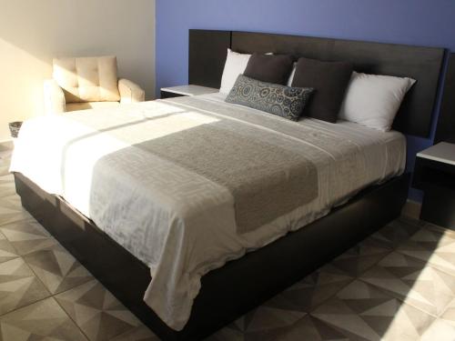 a bedroom with a large bed with a black frame at Hotel Corona Plaza in Rosarito