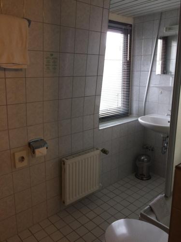 ein Bad mit einem Waschbecken, einem WC und einem Fenster in der Unterkunft Landhotel Elterlein in Elterlein