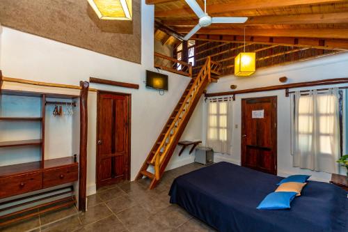 a bedroom with a blue bed and a staircase at Del Wawa in Máncora
