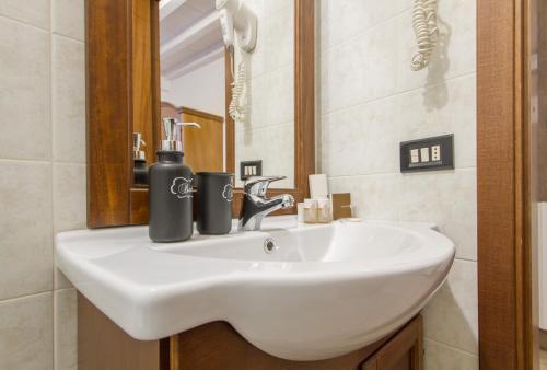 a bathroom with a white sink and a mirror at Le Camere Di Aladino in Carugate