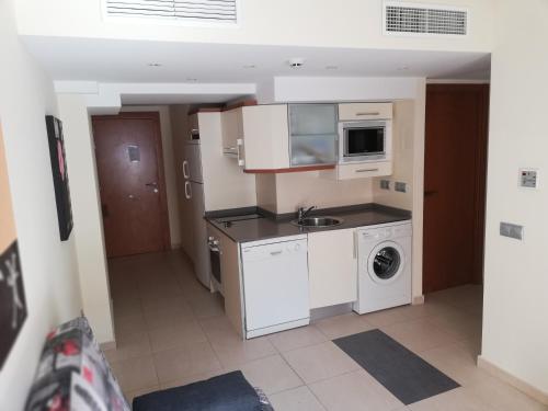 a small kitchen with a sink and a microwave at Marina Rey Aparthotel Playa de Puerto Rey Almeria in Vera