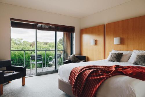 a bedroom with a large bed and a balcony at Royal Mail Hotel in Dunkeld