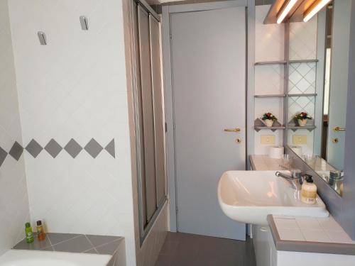 Un baño con un lavabo blanco y un espejo. en la casetta, en Abbadia Lariana