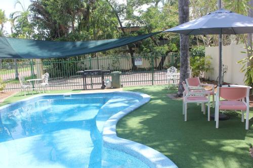 a patio area with a pool table and chairs at Paravista Motel in Darwin