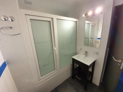 a white bathroom with a sink and a mirror at LiveUshuaia Beagle View in Ushuaia