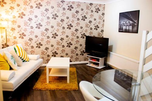 a living room with a couch and a tv at Kempston Cosy Lodge in Bedford