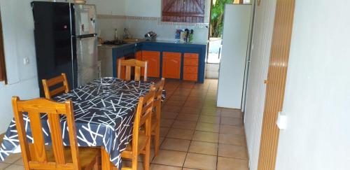 a kitchen with a table and chairs and a refrigerator at Kaloan in Capesterre-Belle-Eau