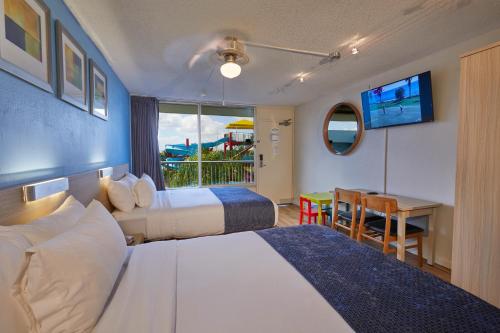 um quarto de hotel com duas camas e uma mesa em Flamingo Waterpark Resort em Kissimmee