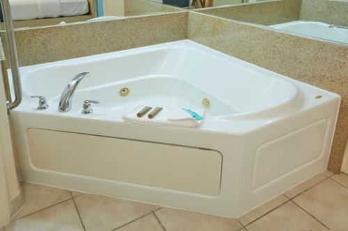 El baño incluye bañera blanca con lavamanos. en Flamingo Waterpark Resort en Kissimmee