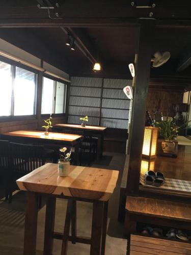 Zimmer mit einem Tisch und einer Bar mit Fenstern in der Unterkunft Minshuku Hiroshimaya in Kumamoto