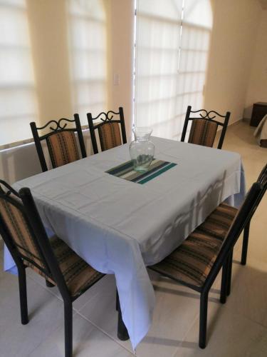 - une table à manger avec une nappe et des chaises blanches dans l'établissement KIA - PESQUERIA - AEROPUERTO MONTERREY a, à Monterrey