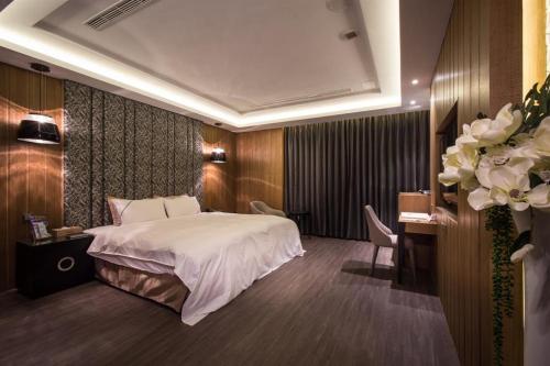 a hotel room with a bed and a desk and a room at U-Her Hotel in Taichung