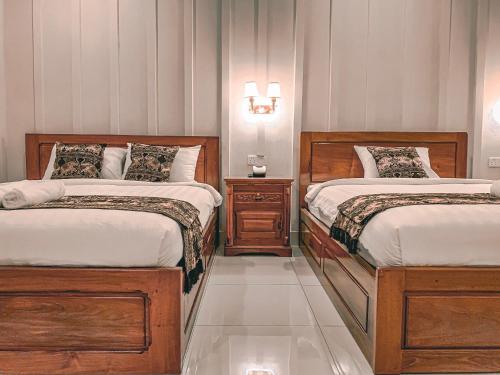 a bedroom with two beds and two night stands at Montagne Regency in Kampot