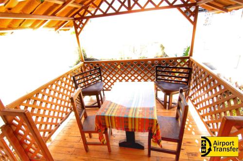 a wooden deck with a table and chairs on it at Hostal Alpachaca - New Quito Airport in Tababela