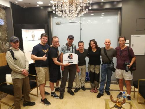 a group of people posing for a picture holding a sign at Cleopatra Pyramids View Hotel in Cairo