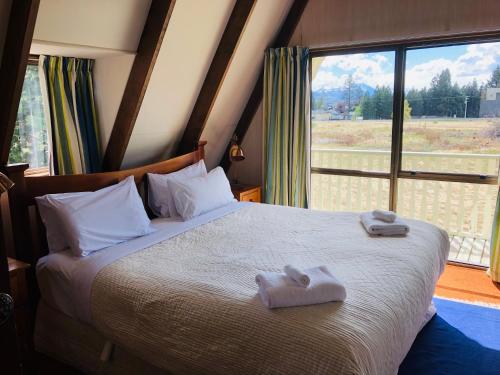 a bedroom with a large bed with towels on it at Arosa - Lake Tekapo in Lake Tekapo