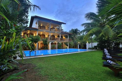 a house with a swimming pool in front of it at Sandali Walauwa in Bentota