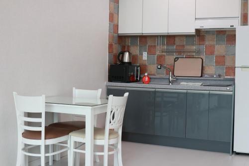 a small kitchen with a white table and chairs at Hallstatt in Suncheon