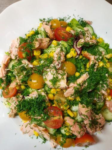 a white plate with a salad with tomatoes and other vegetables at Chata nad Sztolnią in Bystrzyca Górna