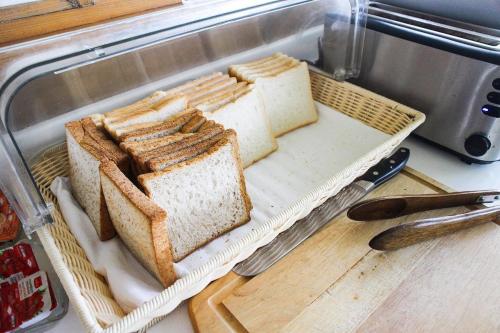 a basket of bread on a counter with a knife at The Vista Pool Villa in Kanchanaburi