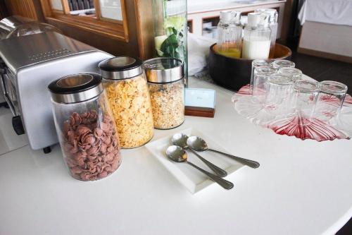 a counter with three jars of food and spoons at The Vista Pool Villa in Kanchanaburi