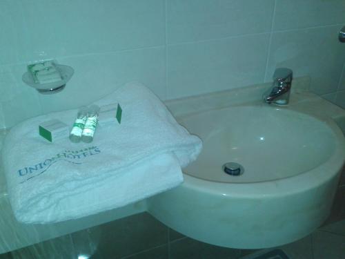 a bathroom with a white towel and a sink at Hotel Zenith in Cervia