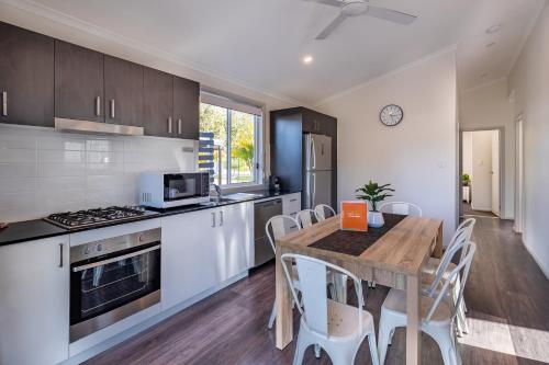 a kitchen with a wooden table and a dining room at Ingenia Holidays One Mile Beach in One Mile