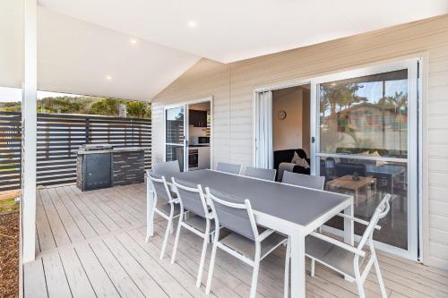a patio with a table and chairs on a deck at Ingenia Holidays One Mile Beach in One Mile