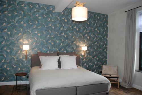 um quarto com uma cama e uma parede com papel de parede de pássaro em Monsieur Doute em Durbuy