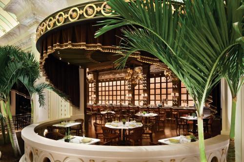 a restaurant with tables and chairs and a palm tree at River City Casino and Hotel in Lemay
