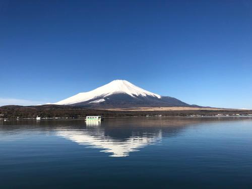 a mountain sitting on top of a large body of water at Vegetarian House Jamoo in Yamanakako