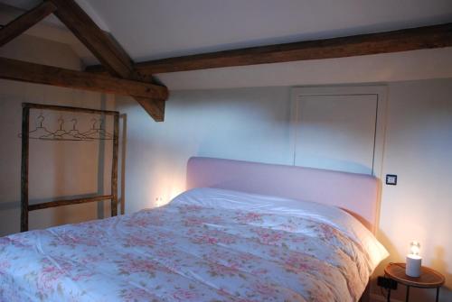 a bedroom with a bed with a floral bedspread at Monsieur Doute in Durbuy