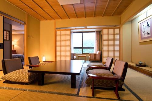 a dining room with a table and chairs at Yumoto Konpira Onsen Hananoyu Kobaitei in Kotohira