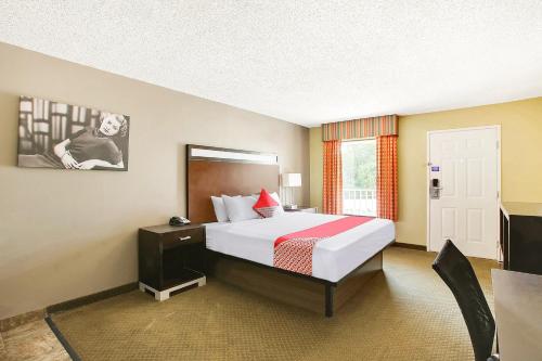 a hotel room with a large bed and a window at OYO Hotel Texarkana Trinity AR Hwy I-30 in Texarkana