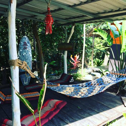 a hammock on a deck with pillows at Freedom home in Ko Chang