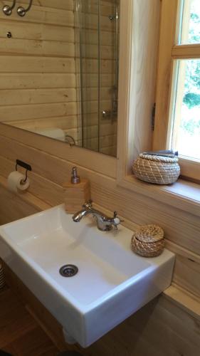 a white sink in a bathroom with a mirror at Vodenica Vrelo Chalets in Vrelo Koreničko