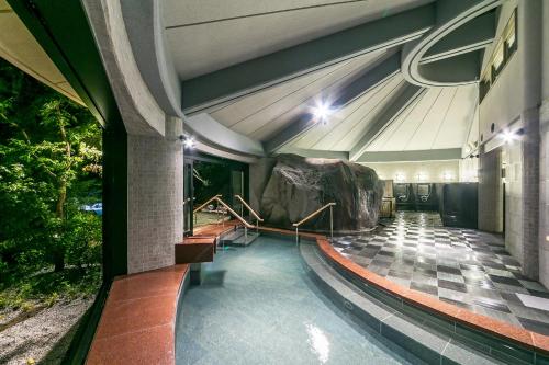 a lobby of a building with a rock on the floor at Tateshina Grand Hotel Takinoyu in Chino