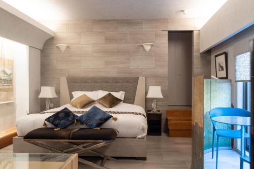 a bedroom with a bed and a blue chair at Luxury Condo Shikine An Gion Shirakawa in Kyoto