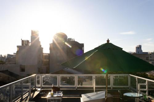 a table with a green umbrella on top of a building at Luxury Condo Shikine An Gion Shirakawa in Kyoto