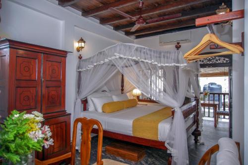 a bedroom with a bed with a canopy at Dutch Wall Fort in Galle