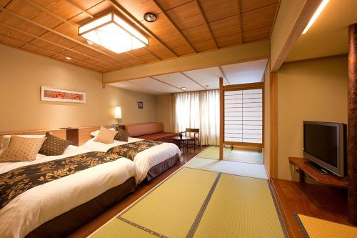 ein Hotelzimmer mit 2 Betten und einem TV in der Unterkunft Yumoto Konpira Onsen Hananoyu Kobaitei in Kotohira