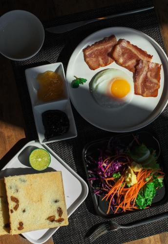 a plate of food with an egg and a salad at Yakamoz Erhai Hotel in Dali