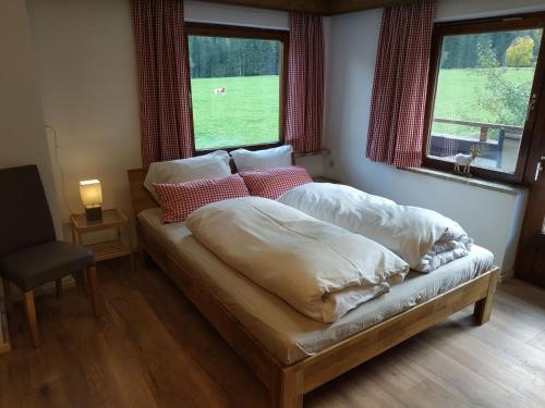 een slaapkamer met een bed met kussens en een raam bij Haus Gartner 4-5 pers appartement in Sulzau
