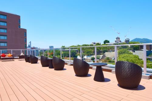 a row of tables and benches on a roof at &and COMFY HOTEL Kumamoto Jo View in Kumamoto