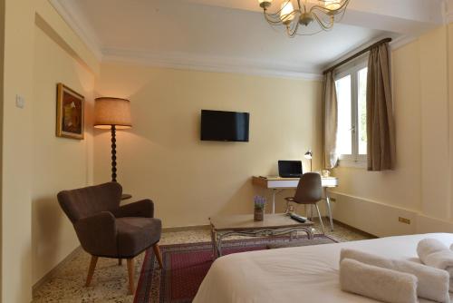 Habitación de hotel con cama, silla y escritorio. en Acro&Polis, en Atenas
