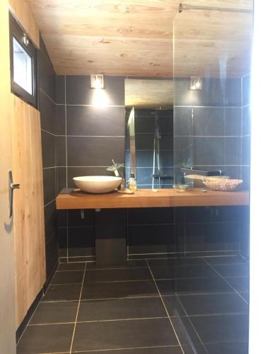 une salle de bain avec un lavabo et un miroir dans l'établissement La Bastide, à Lagrange