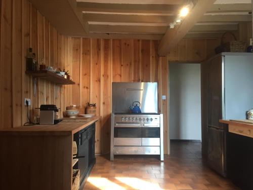 a kitchen with a stainless steel refrigerator and wooden walls at La Bastide in Lagrange