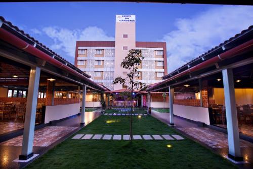 Blick auf ein Gebäude mit einem Rasen in der Mitte in der Unterkunft Hotel RK Gardenia in Bangalore